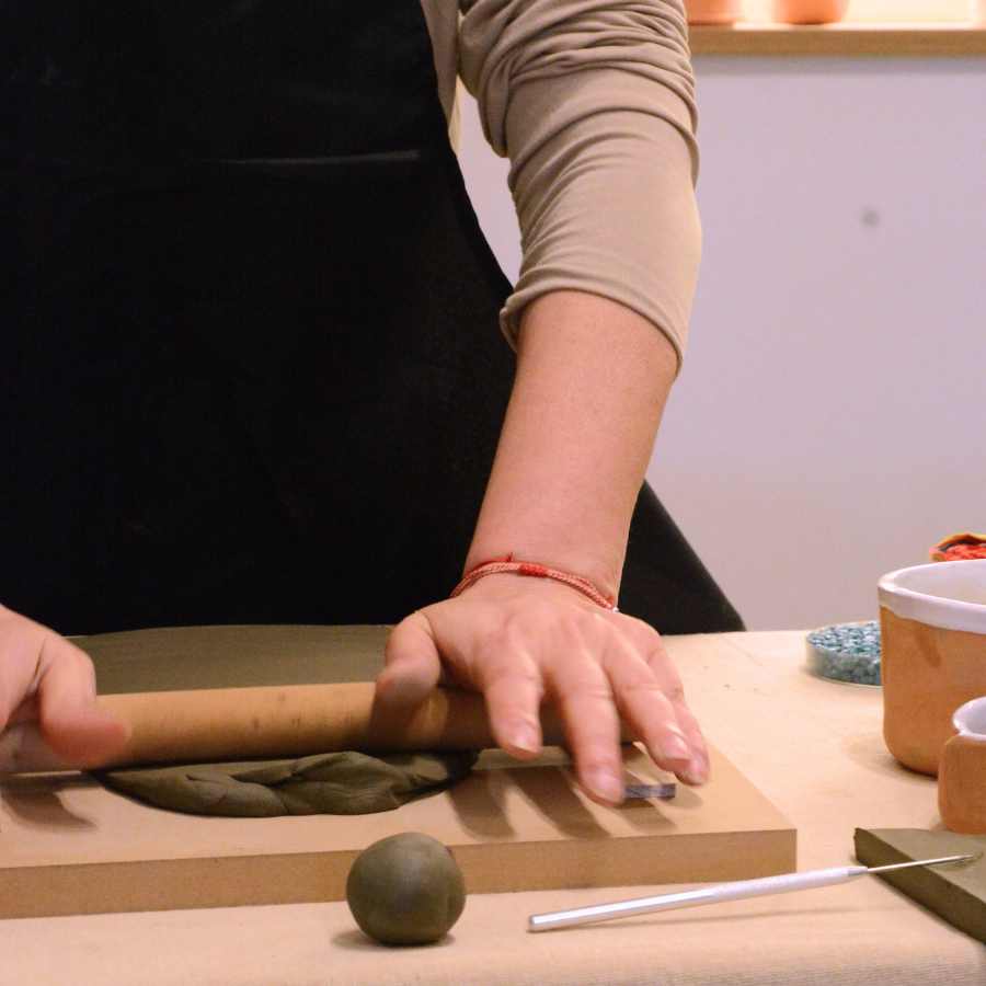 Participantă întinzând o placă de lut la un atelier ghidat