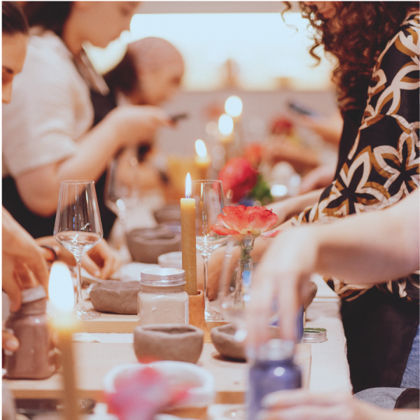 Grup de persoane lucrând cu lutul la un eveniment privat în atelier